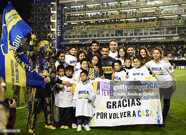 Carlos Tevez poses for pictures with children of Fundacion Carlos Tevez during his presentation as new player of Boca Juniors at Alberto J. Armando...