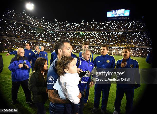 Carlos Tevez walks on the field with his daughter during his presentation as new player of Boca Juniors at Alberto J. Armando Stadium on July 13,...