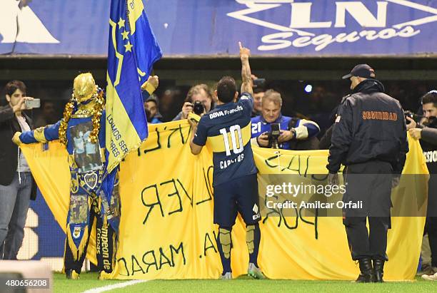 Carlos Tevez receives Diego Maradona's flag during his presentation as new player of Boca Juniors at Alberto J. Armando Stadium on July 13, 2015 in...