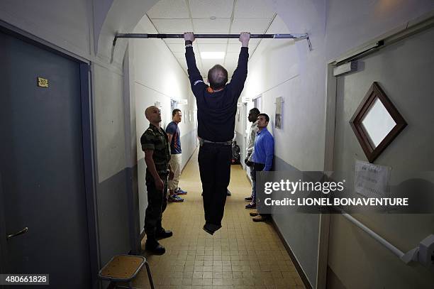 Recruit of the French Foreign Legion does pulls in front of other recruits and a soldier at the recruitment center in Fontenay-sous-bois, outside...