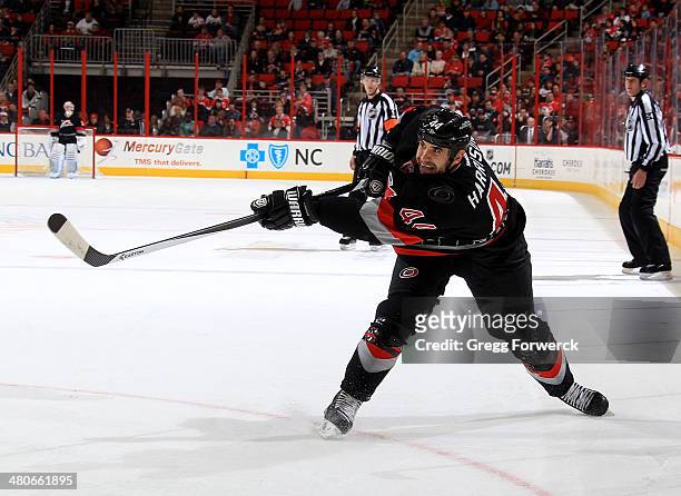 Jay Harrison of the Carolina Hurricanes shoots the puck during their NHL game against the Edmonton Oilers at PNC Arena on March 16, 2014 in Raleigh,...