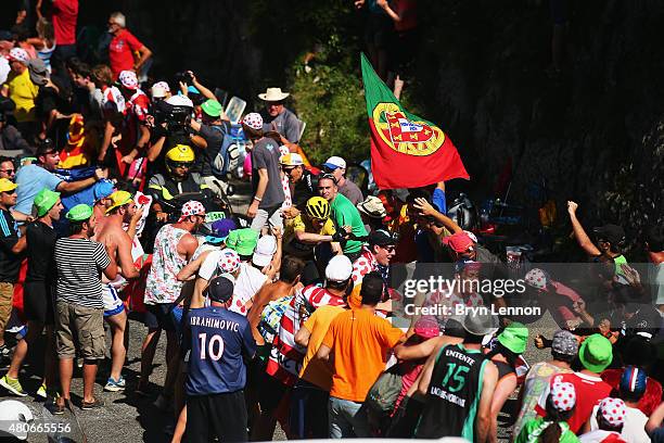 Chris Froome of Great Britain and Team Sky signals to fans to move out of the way as he climbs the Col de Soudet during stage ten of the 2015 Tour de...