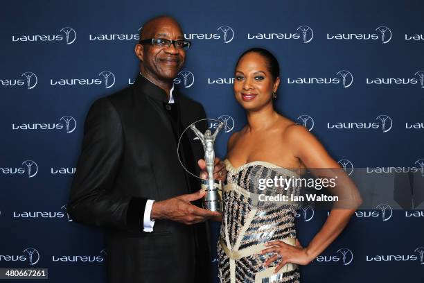 Academy Chairman Edwin Moses and wife Michelle pose with the trophy during the 2014 Laureus World Sports Awards at the Istana Budaya Theatre on March...