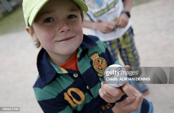 Boy shows a golf ball signed by US golfer Jordan Spieth during practice on The Old Course at St Andrews in Scotland, on July 14 ahead of The 2015...