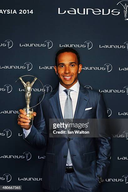 Motor racing driver Lewis Hamilton poses with the trophy during the 2014 Laureus World Sports Awards at the Istana Budaya Theatre on March 26, 2014...