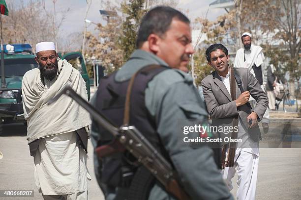 An Afghan National Police officer stands guard at the gate of the provinial office complex which houses the office of Haji Niyaz Mohammad Amirii,...