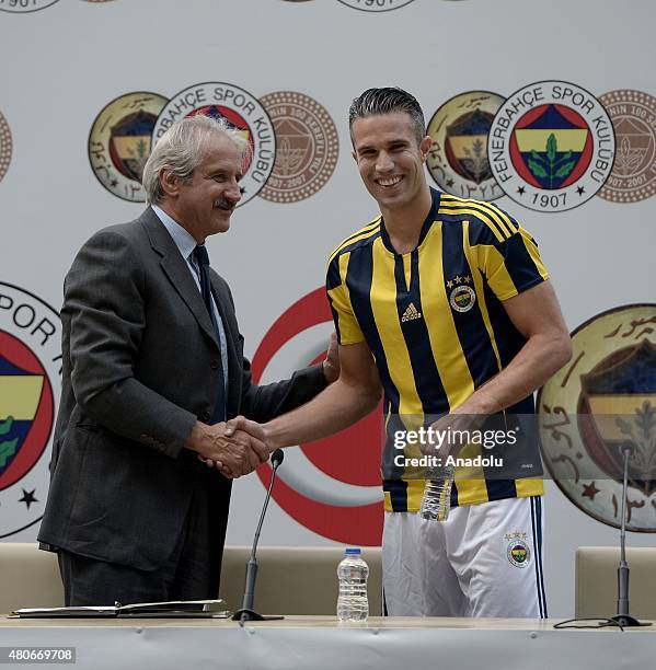 Fenerbahce's new transfer Dutch footballer Robin van Persie shakes hand Fenerbahce sporting director Giuliano Terraneo after signing four-year...