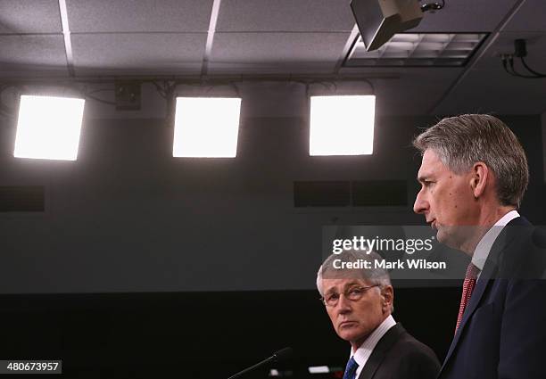 Secretary of Defense Chuck Hagel and United Kingdom Secretary of State for Defense Philip Hammond answer questions from the media during a briefing...