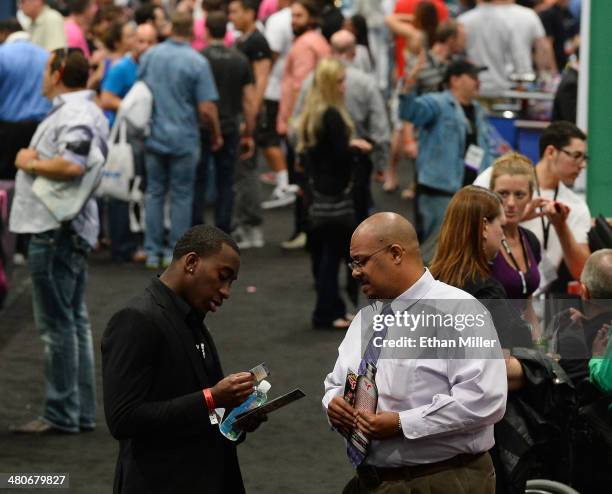 Attendees talk at the Rush Flyers booth at the 29th annual Nightclub & Bar Convention and Trade Show at the Las Vegas Convention Center on March 25,...