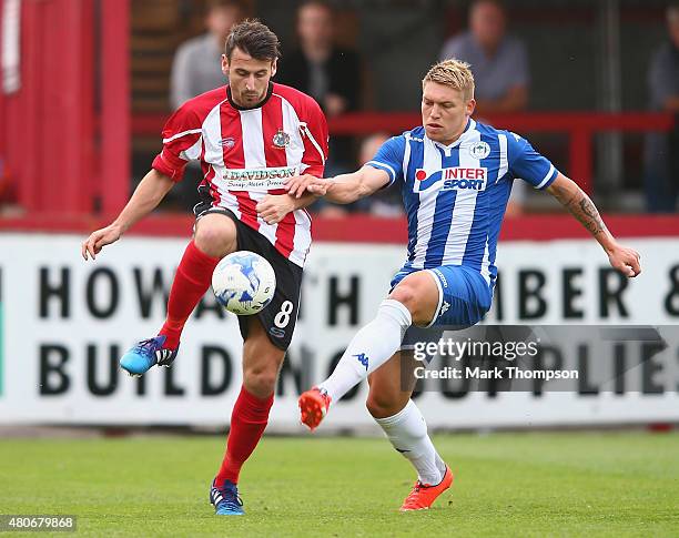 Simon Richman of Altrincham tangles with Martyn Waghorn of Wigan Athletic during the pre season friendly between Altrincham and Wigan Athletic at the...