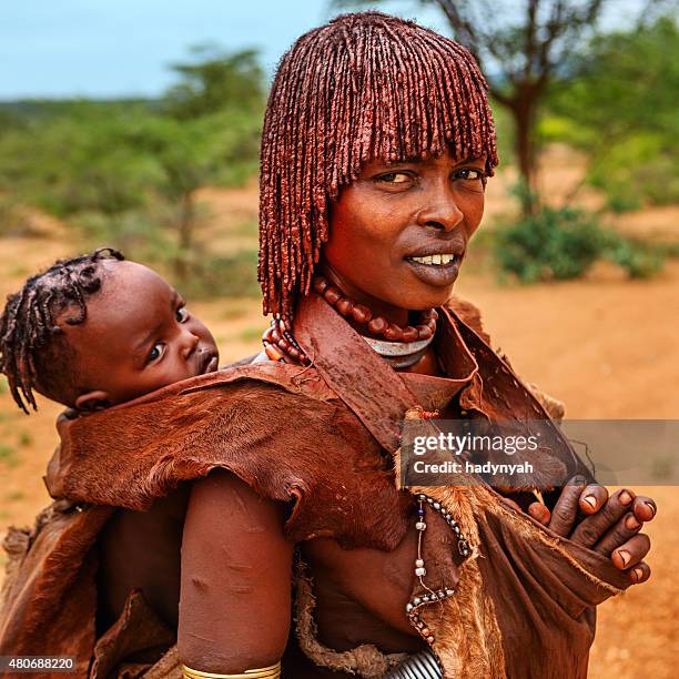 femme de culture hamer, éthiopie portant son bébé, afrique - hamar photos et images de collection