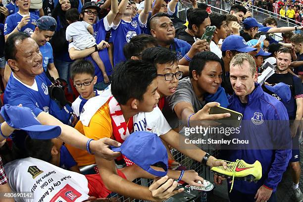 Tony Hibbert of Everton poses with fans during the Everton FC open training ahead of the match between Everton and Stoke City during the 2015...