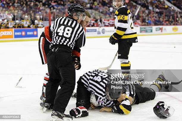 Linesmen Pat Smith and Dave Borden separate Ryan Van Stralen of the Ottawa 67's and Loren Ulett of the Kingston Frontenacs following a fight during...