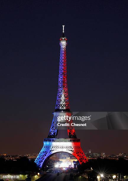 The Eiffel Tower is enlightened with colors of the French national flag prior to the beginning of the fireworks on July 14, 2015 as part of France's...