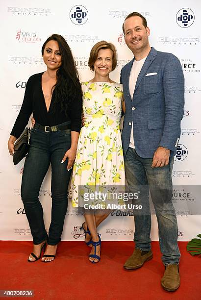 Designers Erik Nelson and Emily Cummings poses with actress Olivia Blois Sharpe on the red carpet at the Edinger Apparel presentation during New York...