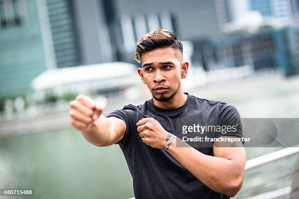 asiatische fighter mann macht eine punching boxen training - bodybuilding furious stock-fotos und bilder
