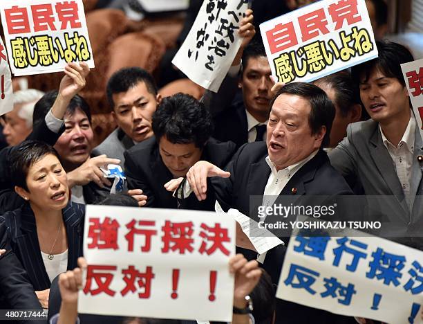 Yasukazu Hamada , chairman of a parliamentary panel on Japanese Prime Minister Shinzo Abe's controversial security bills, is surrounded by opposition...