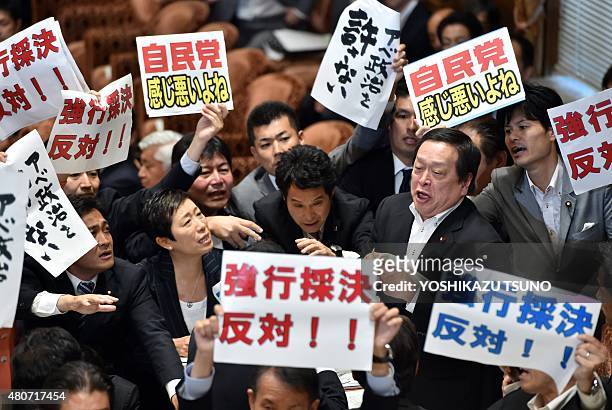 Yasukazu Hamada , chairman of a parliamentary panel on Japanese Prime Minister Shinzo Abe's controversial security bills, is surrounded by opposition...