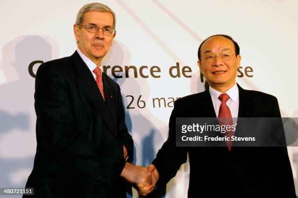 Philippe Varin , chairman of the PSA Peugeot Citroen shakes hands with Xu Ping , chairman of the board of directors of Dongfeng, after the end of...