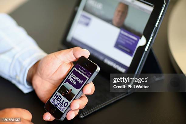 Internet Party CEO Vikram Kumar shows the sign up app on his smartphone after the Internet Party was launched by Kim Dotcom at the Dotcom Mansion on...