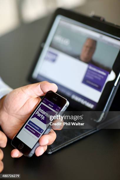 Internet Party CEO Vikram Kumar shows the sign up app on his smartphone after the Internet Party was launched by Kim Dotcom at the Dotcom Mansion on...