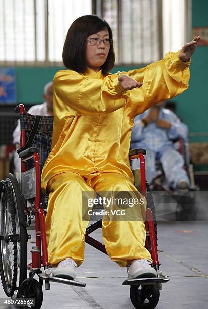 Woman with lower-limb disabilities sitting in wheelchairs plays Tai Chi Chuan in Xuanhua District on July 15, 2015 in Zhangjiakou, Hebei Province of...
