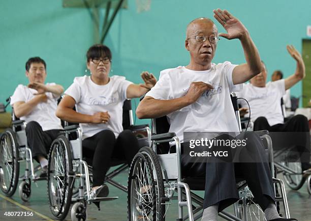 People with lower-limb disabilities sitting in wheelchairs play Tai Chi Chuan in Xuanhua District on July 15, 2015 in Zhangjiakou, Hebei Province of...