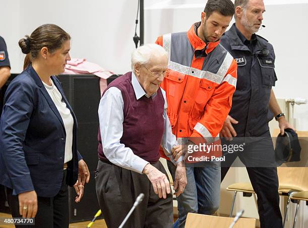 Oskar Groening a former member of the Waffen-SS who worked at the Auschwitz concentration camp during World War II, is helped into court by lawyer...