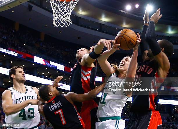 Kelly Olynyk of the Boston Celtics attempts to grab a loose rebound in front of Terrence Ross and Kyle Lowry of the Toronto Raptors in the second...