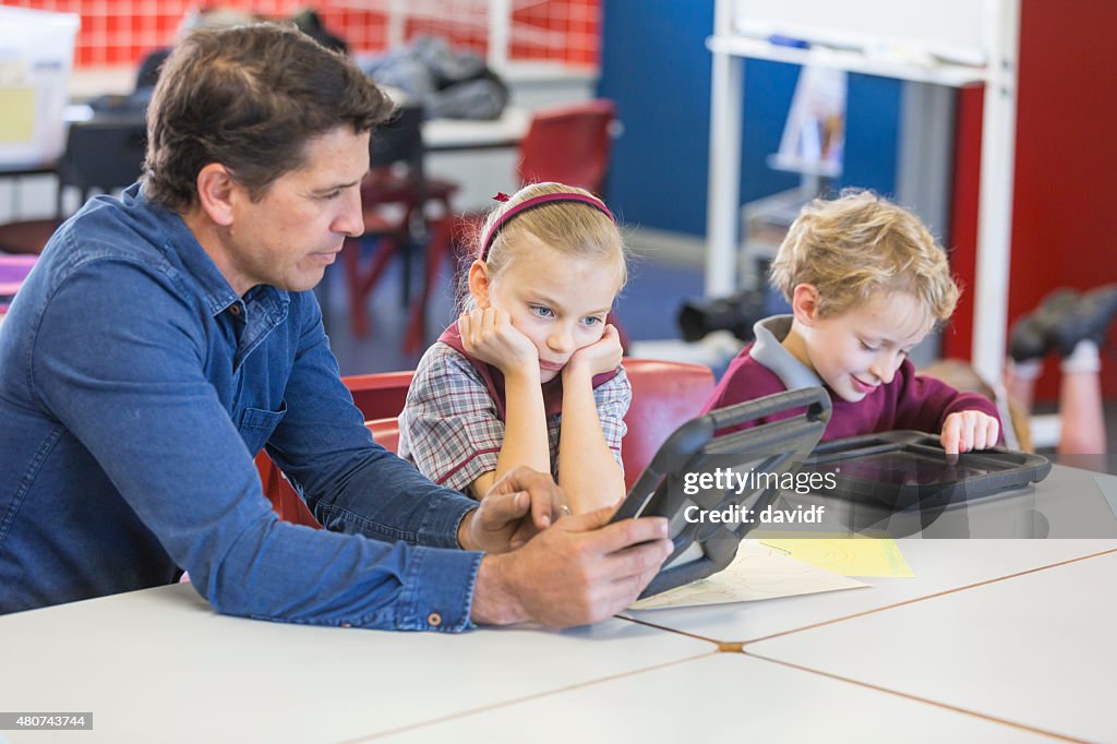 Teacher Giving Lesson Using a Tablet Computer in the Classroom