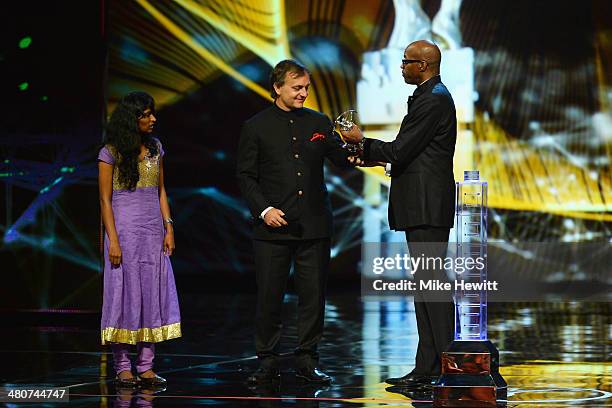 Laureus Academy Chairman Edwin Moses speaks onstage before giving Matthew Spacie with Parvati the Sport for Good award for the Magic Bus project...