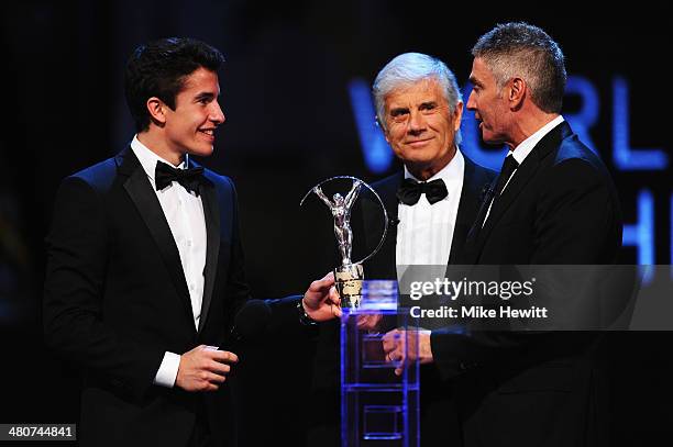 Motor cyclist Marc Marquez accepts his Laureus World Breakthrough of the Year award from Laureus Academy member Giacomo Agostini and Mick Doohan...