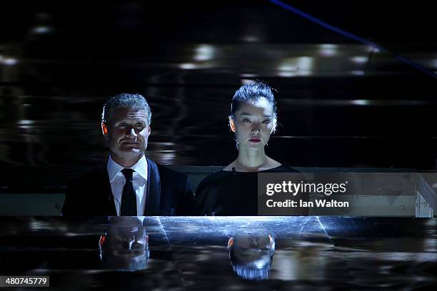 Laureus Ambassador David Coulthard and model Du Juan walk on stage during the 2014 Laureus World Sports Award show at the Istana Budaya Theatre on...