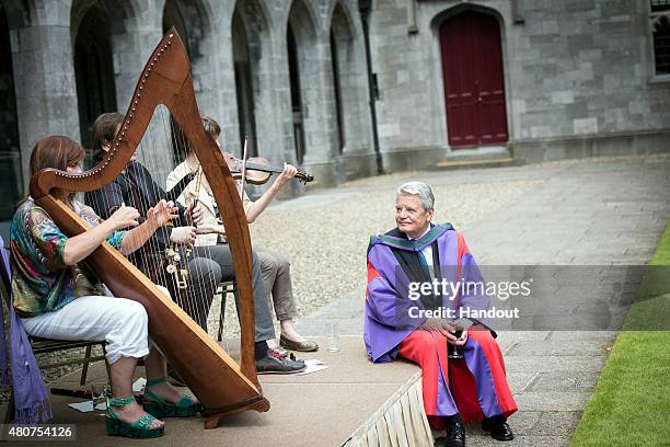 In this handout photo provided by the German Government Press Office , German President Joachim Gauck listens to violine, harp and Uilleann Pipes...