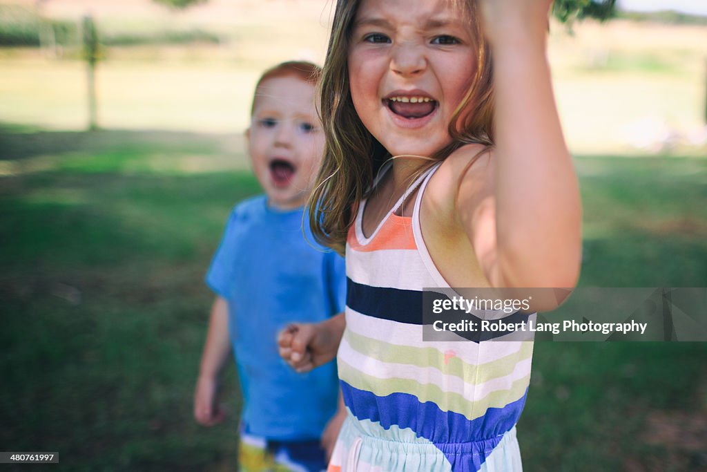 Big sister and little brother outside playing