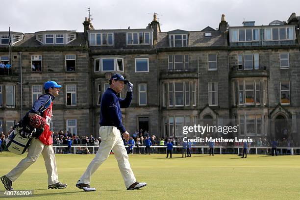 Tom Watson of the United States tips his cap as he walks down the first fairway with caddie Michael Watson during the Champion Golfers' Challenge...