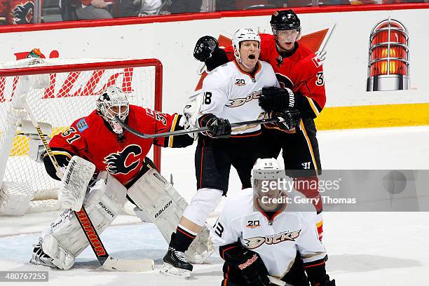 Karri Ramo and Ladislav Smid of the Calgary Flames skate against Tim Jackman of the Anaheim Ducks at Scotiabank Saddledome on March 26, 2014 in...