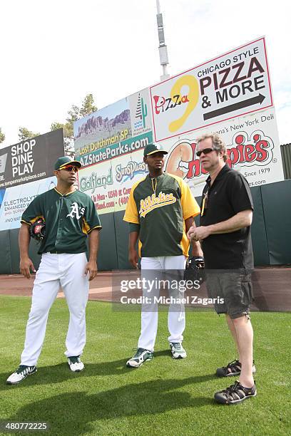 Fernando Nieve and Raul Alcantara of the Oakland Athletics stand on the field with Flipboard photo editor Steve Fine prior to a spring training game...