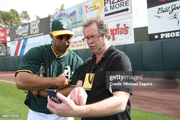 Fernando Nieve of the Oakland Athletics talks with Flipboard photo editor Steve Fine prior to a spring training game against the San Francisco Giants...