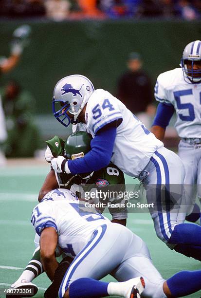 Chris Spielman and Broderick Thomas of the Detroit Lions tackles Art Monk of the New York Jets during an NFL football game December 10, 1994 at The...