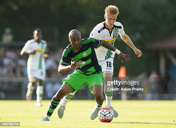 Andre Ayew of Swansea is challenged by Marvin Schulz of Borussia Moenchengladbach during the City Preseason Friendly between Borussia...