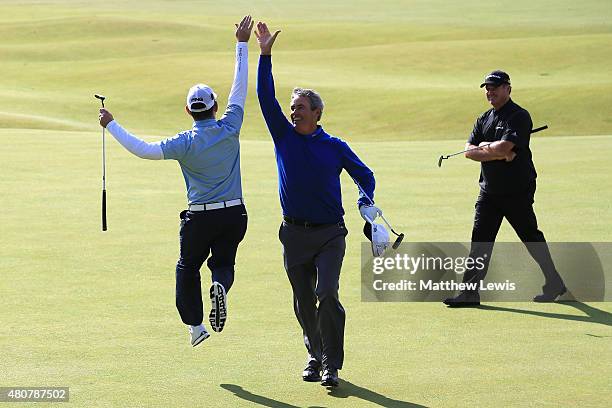 Ian Baker-Finch of Australia and Louis Oosthuizen of South Africa 'high five' on the 18th green as Todd Hamilton of the United States looks on during...