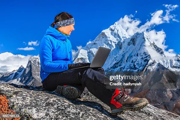 woman is using laptop in mount everest national park, nepal - mountain view stock pictures, royalty-free photos & images