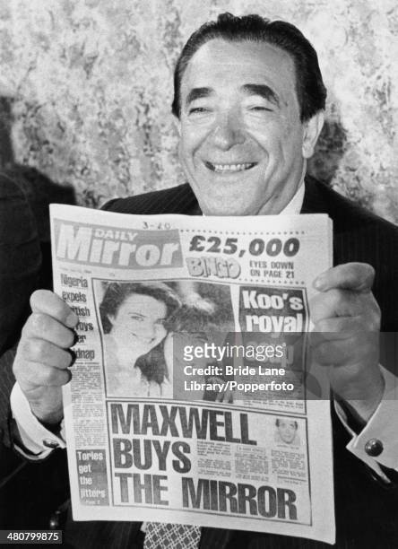 British publisher Robert Maxwell holding a copy of the Daily Mirror newspaper at a press conference to announce his acquisition of Mirror Group...