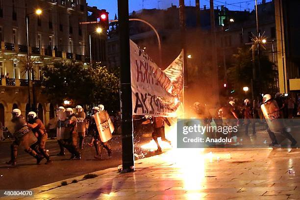 Riot police forces clash with protesters in front of the Greek Parliament during an anti-austerity demonstration in Athens on July 15, 2015 while...