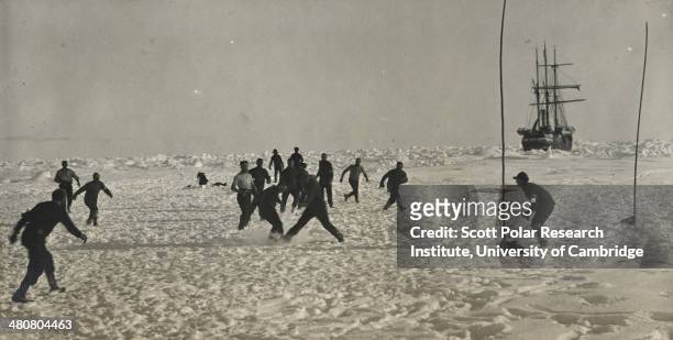 Soccer game during a 'hold-up' in the Imperial Trans-Antarctic Expedition, 1914-17, led by Ernest Shackleton. The 'Endurance' is in the background.