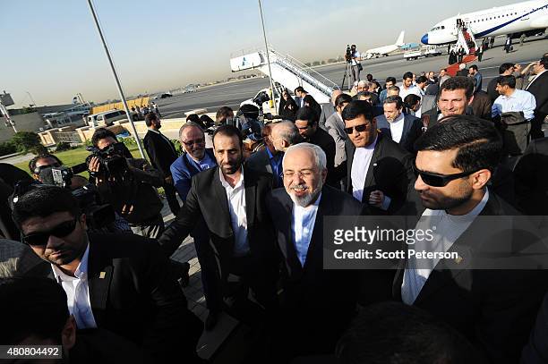 Iranian Foreign Minister Mohammad Javad Zarif laughs after touching down on Iranian soil after signing a landmark nuclear deal between Iran and six...