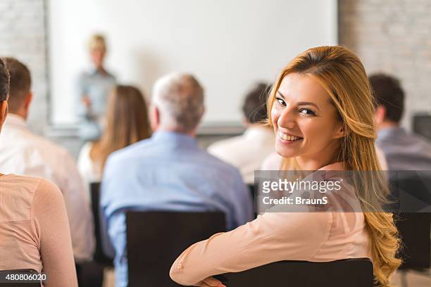 young happy geschäftsfrau teilnahme an business education event. - teilnehmen stock-fotos und bilder