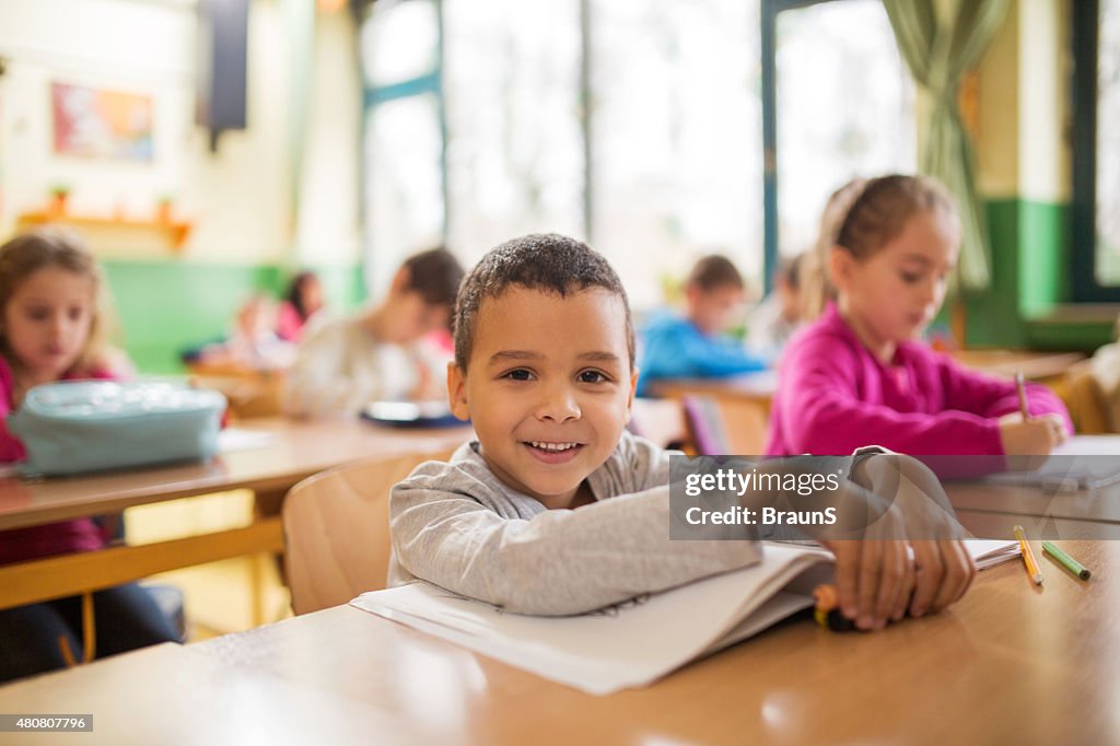 Happy African American schoolboy during a class in the classroom.