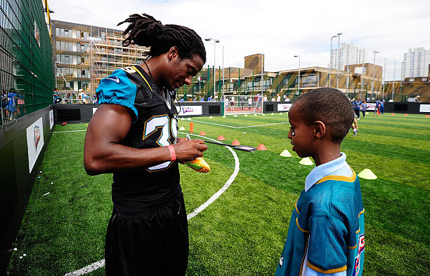Sergio Brown of the Jacksonville Jaguars signs an autograph for a kid at a local school during the NFL's launch of Play 60 at Black Prince...